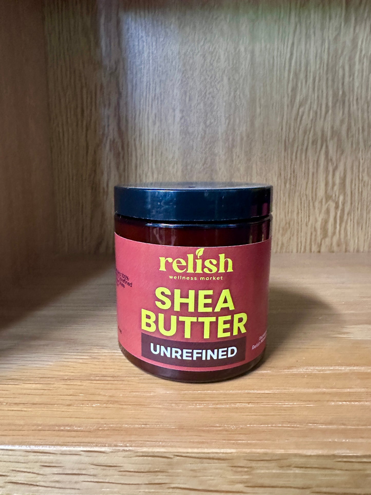 Jar of Relish Market shea butter on a wooden surface