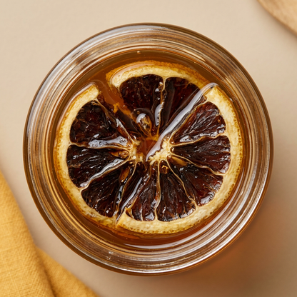 Top view of an opened jar of Bourbon Citrus Honey by Relish Market. Orange peel and honey are visible.