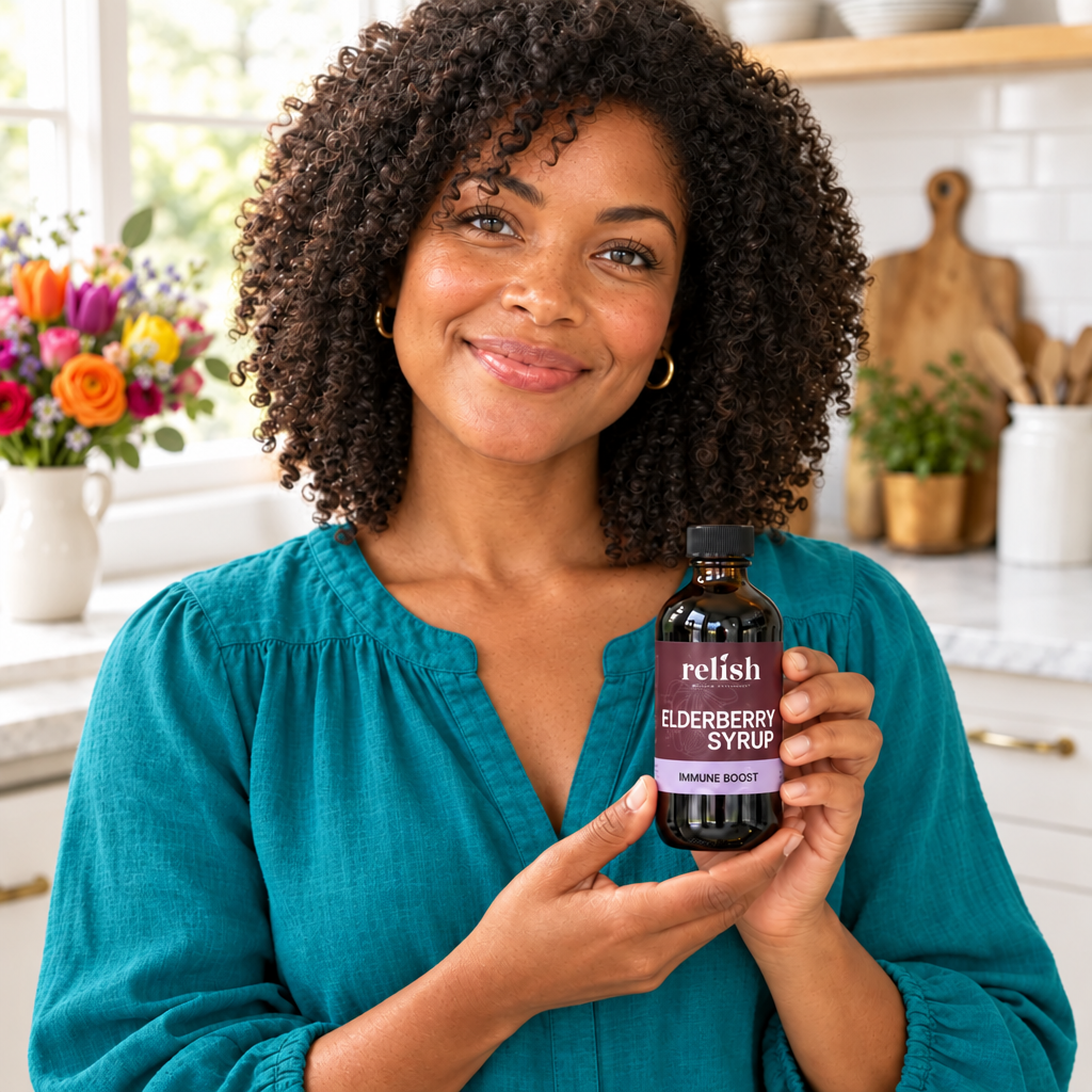 Woman in a colorful teal top holding Relish Market elderberry syrup in a brightly lit kitchen.