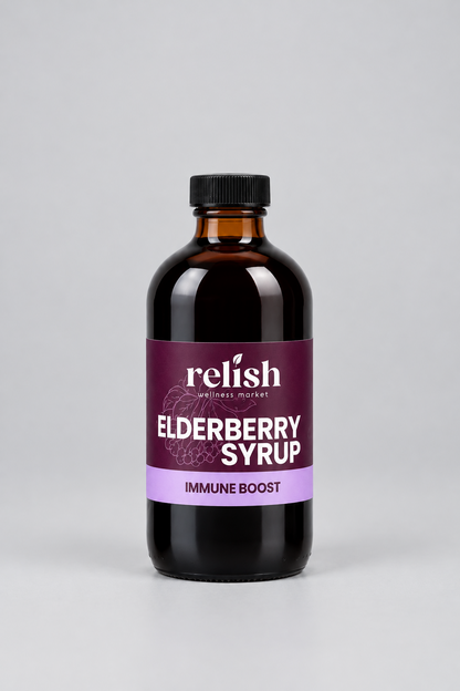 A bottle of Relish Market Elderberry Syrup with an amber glass body, black cap, and a purple label, centered on a light gray background.