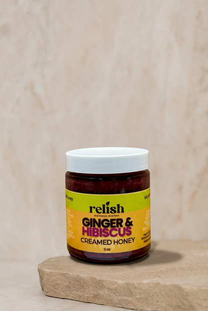 Ginger & Hibiscus Creamed Honey by Relish Market on a stone slab with a neutral background.
