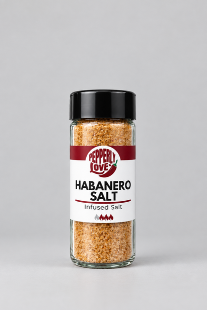 A clear glass bottle of Pepperly Love Habanero Salt with a black lid and a white label, set against a neutral light gray background.