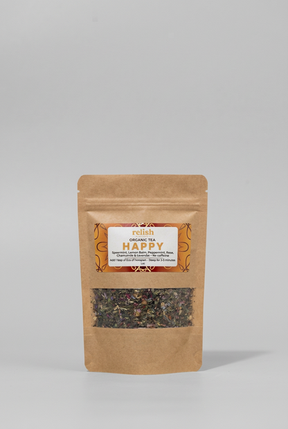 A stand-up kraft paper pouch of Relish Market Organic Tea Happy loose-leaf tea, featuring a clear window showing the dried tea blend inside, set against a neutral gray background.