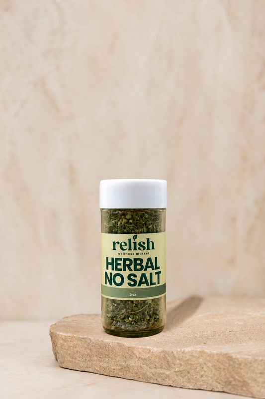 Jar of Herbal No Salt Spice Blend by Relish Market, sitting on a rustic stone slab against a beige textured background.