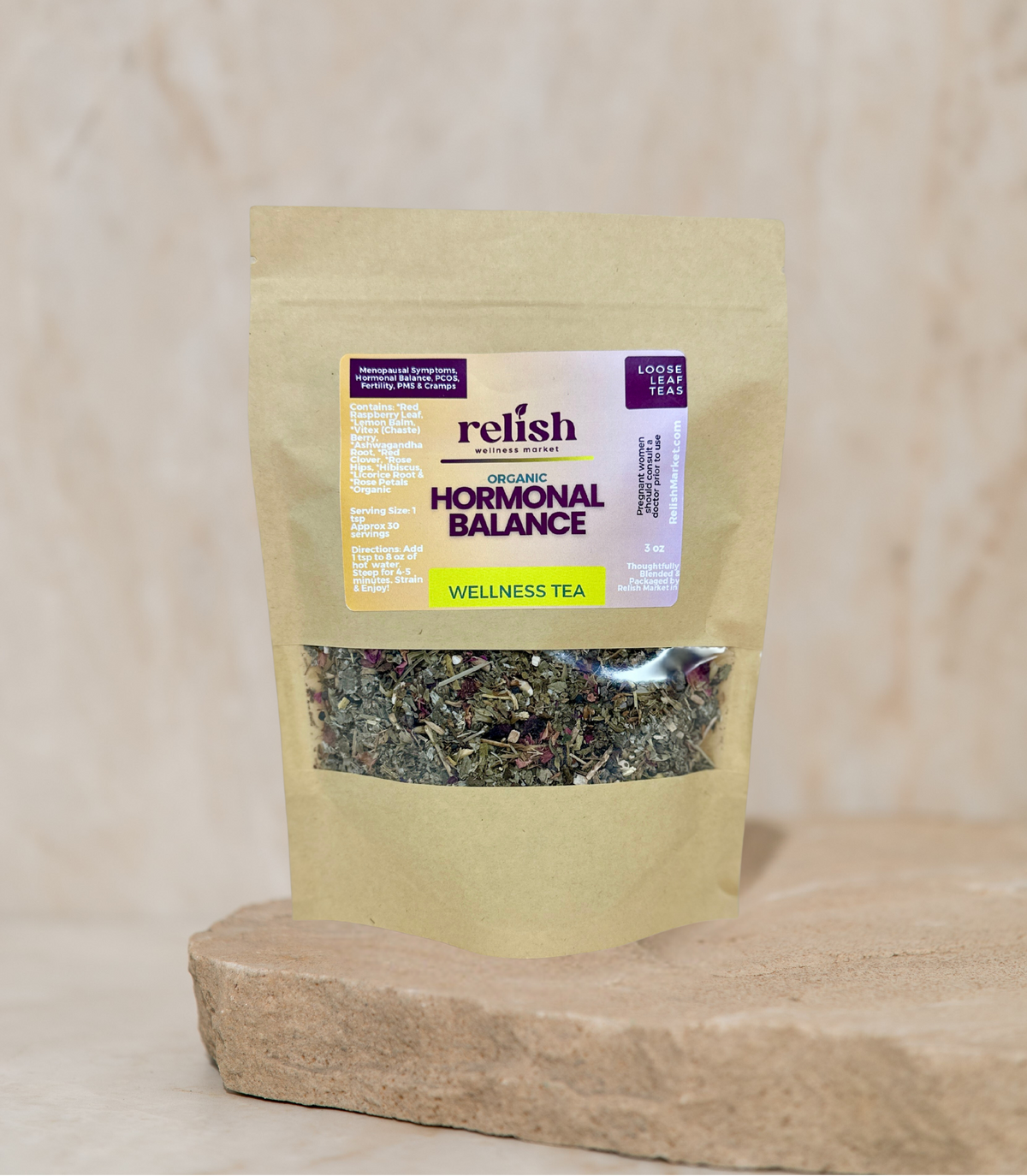 Kraft Bag of Relish Market Hormonal Balance Wellness Tea on a stone slab and neutral background.