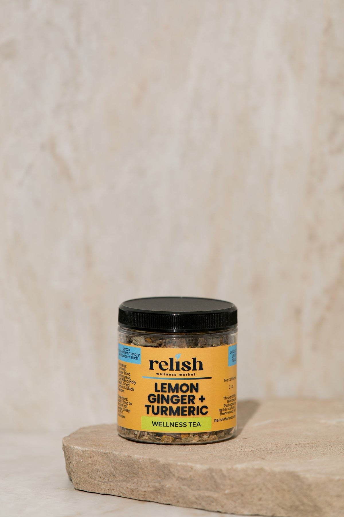 Lemon Ginger Turmeric Tea jar on a stone slab and neutral background.