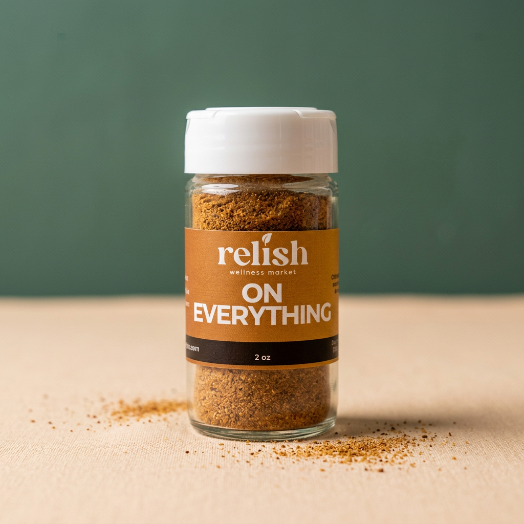 A glass jar of On Everything Spice Blend by Relish Market on a beige and green background.