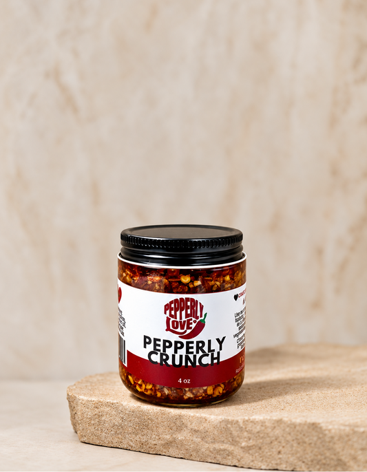 A jar of Pepperly Crunch by Pepperly Love sits on a rustic stone slab against a textured beige background.