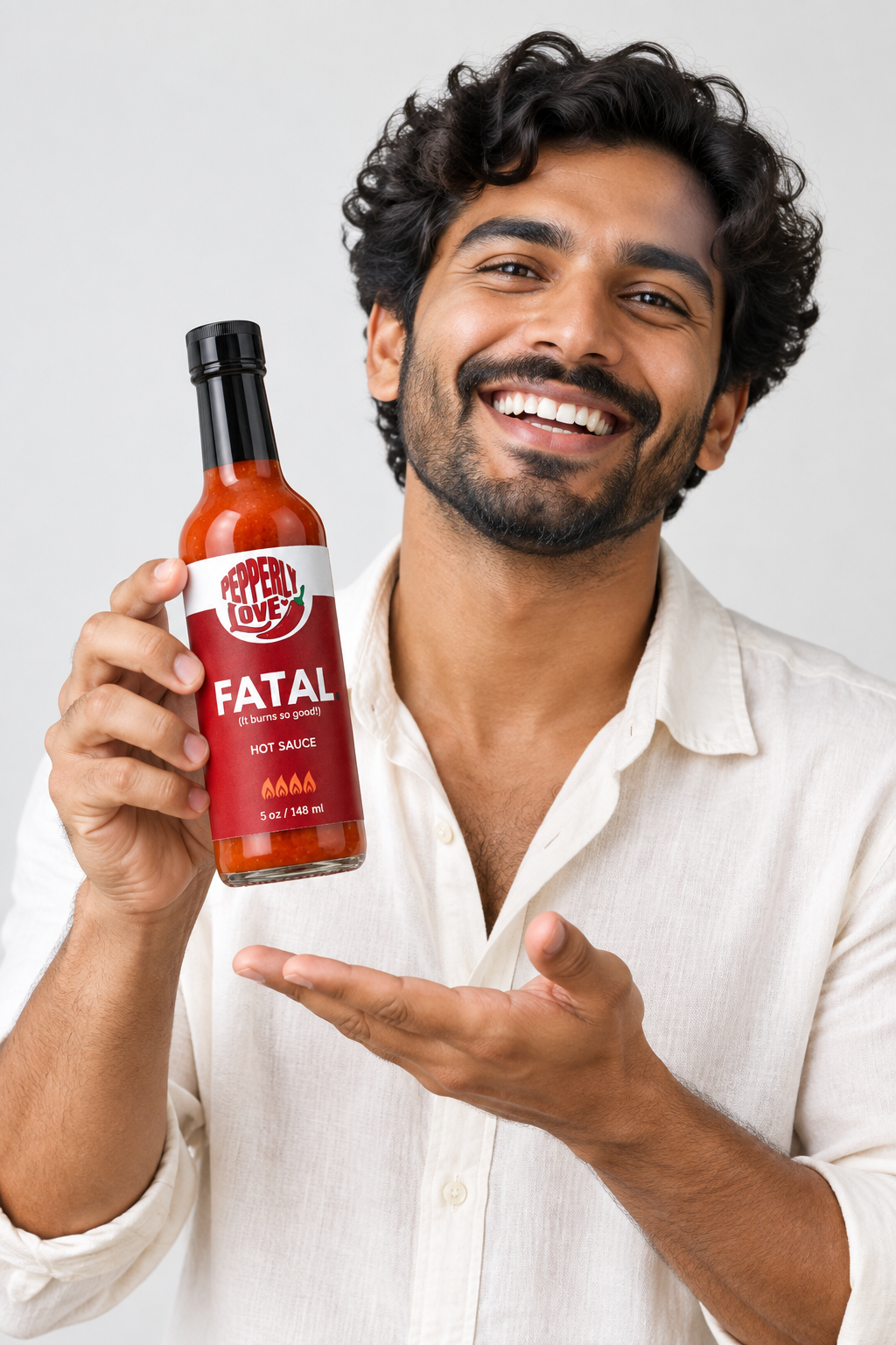 A smiling man in a white shirt holds up a bottle of 'Fatal' hot sauce against a light gray background.