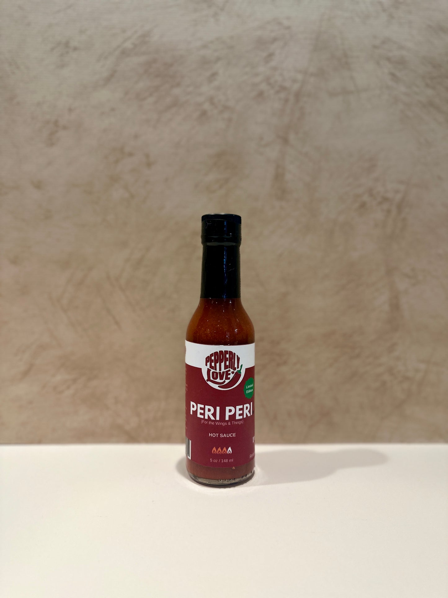 Peri Peri sauce bottle on a beige background
