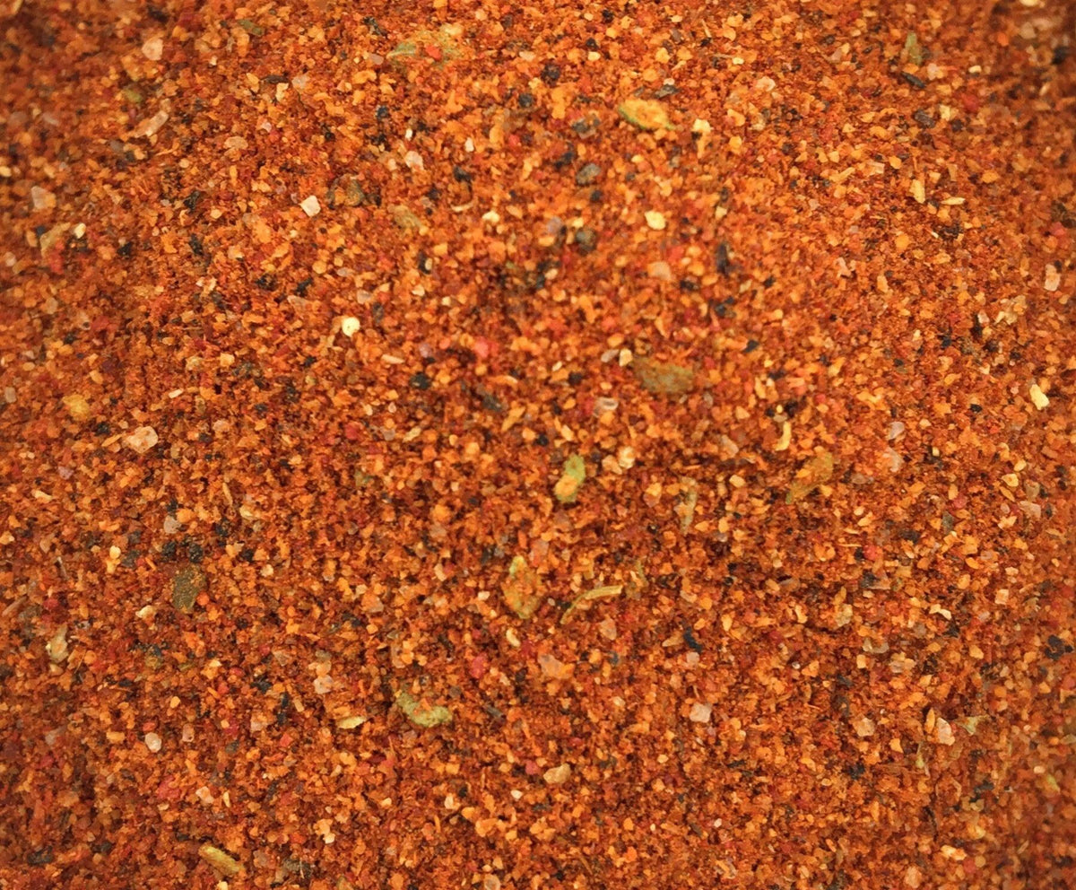 Close-up of Peri Peri Spice Blend by Relish Market - a red spice blend with visible particles.