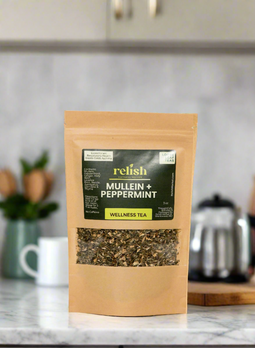 Kraft zip bag of Relish Market mullein & peppermint tea on a marble kitchen counter with a white tea cup and a silver tea kettle in the background.