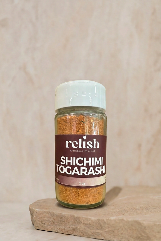 A jar of Shichimi Togarashi Spice Blend by Relish Market on a stone slab with a neutral background. 