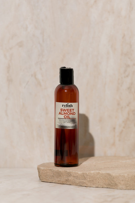 Bottle of sweet almond oil on a stone surface with a neutral background