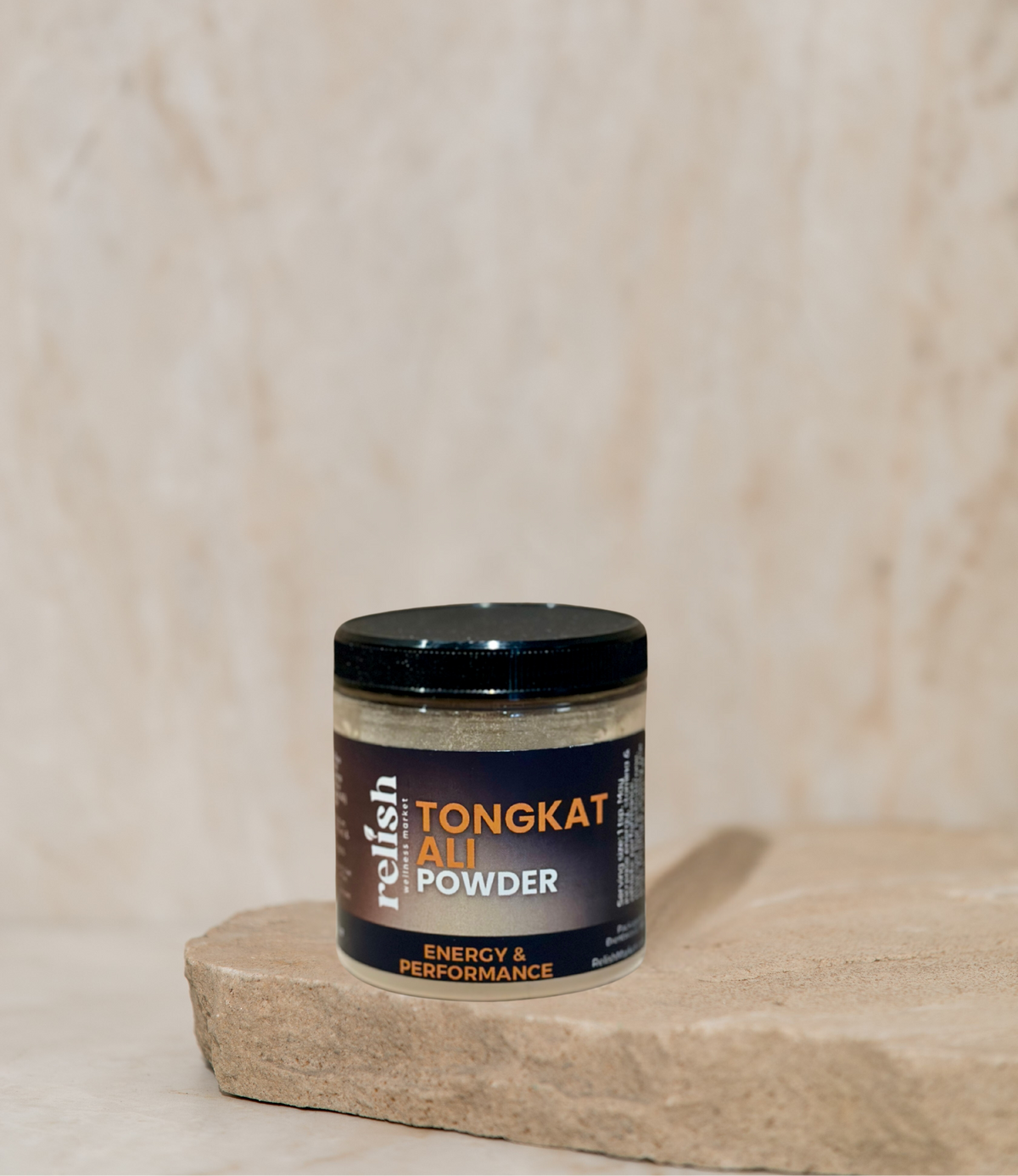 A jar of Relish Market Tongkat All Powder supplement placed on a rustic stone slab against a textured beige background.