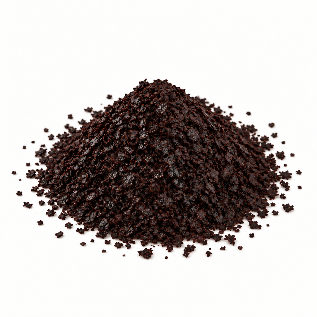 A small mound of dark brown ground Urfa Biber pepper flakes photographed on a clean white background.